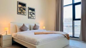 a white bedroom with a large bed and a window at Luxurious apartments at JLT by Checkmyguest in Dubai