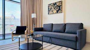 a living room with a blue couch and a glass table at Luxurious apartments at JLT by Checkmyguest in Dubai