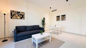 a living room with a blue couch and a table at Luxurious apartments at JLT by Checkmyguest in Dubai