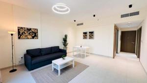a living room with a blue couch and a table at Luxurious apartments at JLT by Checkmyguest in Dubai