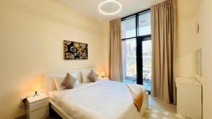 a bedroom with a white bed and a large window at Luxurious apartments at JLT by Checkmyguest in Dubai