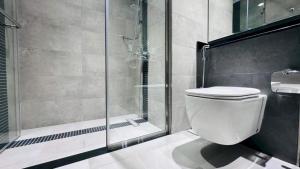 a bathroom with a toilet and a glass shower at Luxurious apartments at JLT by Checkmyguest in Dubai