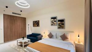 a bedroom with a bed and a blue chair at Luxurious apartments at JLT by Checkmyguest in Dubai