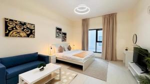 a living room with a bed and a blue couch at Luxurious apartments at JLT by Checkmyguest in Dubai
