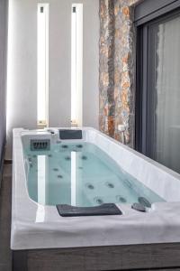 a jacuzzi tub in a bathroom with a window at Lavender Luxury Apartment in Rhodes in Rhodes Town