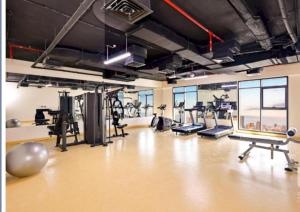 a gym with treadmills and machines in a room at Luxurious apartments at JLT by Checkmyguest in Dubai