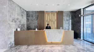 a man sitting at a reception desk in a lobby at Luxurious apartments at JLT by Checkmyguest in Dubai