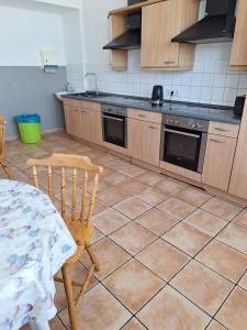 a kitchen with a tiled floor with a table and chairs at H1 Herberge-One Erfurt in Erfurt +6 photos