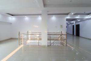 une pièce avec deux étagères métalliques sur un mur dans l'établissement Hotel O Shri Tirupati, à Nalmatha