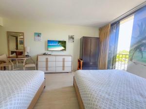 ein Schlafzimmer mit zwei Betten und einem Tisch und einem Fenster in der Unterkunft Waikiki Palms in Paradise apts in Honolulu + 12 Fotos