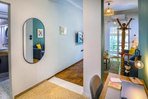 Una sala de estar con un espejo y una mesa. en Koukaki Beat, en Atenas