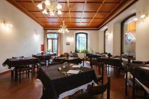 a dining room with tables and chairs and a chandelier at Villa Luzzago in Ponte di Legno