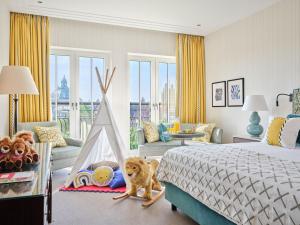 a bedroom with a dog sitting next to a bed at Rocco Forte The Charles Hotel in Munich