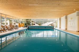 翁根Braunbär Hotel & Spa - Former Alpine Sunstar Hotel的建筑物内设有带椅子的大型游泳池