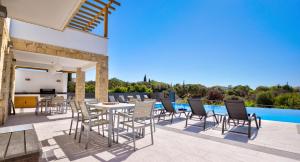un patio con tavolo e sedie accanto alla piscina di Villa 347 Meo - Fantastic Five Bedroom Villa with Private pool in Peaceful Location, Aphrodite Hills a Kouklia