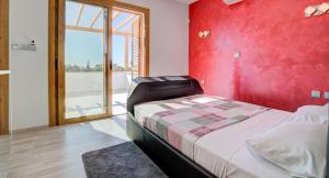 una camera da letto con una parete rossa, un letto e una finestra di Villa 347 Meo - Fantastic Five Bedroom Villa with Private pool in Peaceful Location, Aphrodite Hills a Kouklia Altre 34 foto