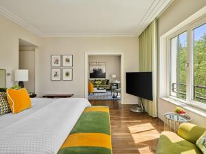 a bedroom with a bed and a flat screen tv at Rocco Forte The Charles Hotel in Munich