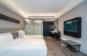 Ένα ή περισσότερα κρεβάτια σε δωμάτιο στο Atour Light Hotel Shanghai Xujiahui Jiaotong University