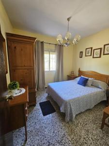 a bedroom with a bed and a chandelier at El Arrabal de la Barrosa in Chiclana de la Frontera