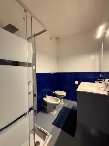 a blue and white bathroom with a toilet and a sink at Cav Casa Brunella in Castiglione della Pescaia +25 photos