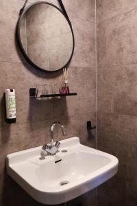 a bathroom with a white sink and a mirror at Hotel de Abdij in Horn