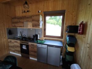 a kitchen with a stove and a window in a cabin at Domki w Beskidach- Agroturystyka" Babiogórski pejzaż" in Pewel Wielka