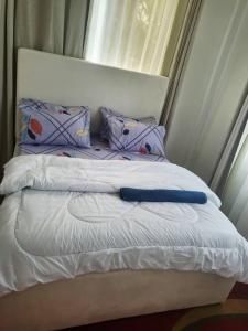 a bed with white sheets and pillows and a window at Bieni Homes in Nkunjila +2 photos
