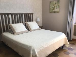 una camera da letto con letto, lenzuola e cuscini bianchi di Le Verger a Gordes Altre 37 foto