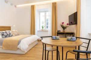 Un dormitorio con una cama y una mesa con sillas. en Soleil Palace, en Dubrovnik