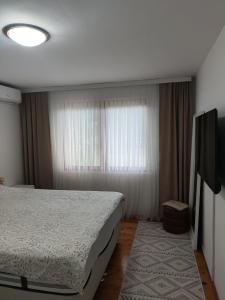 a bedroom with a bed and a window at Butmir house-Sarajevo in Ivišovo Greblje