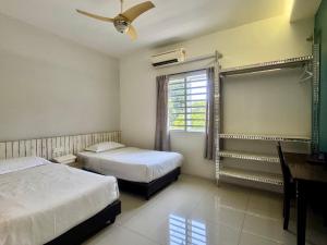 a bedroom with two beds and a desk and a window at Lavender house IPOH in Ipoh
