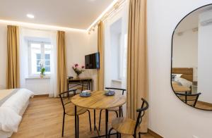 Una habitación de hotel con una mesa y un espejo. en Soleil Palace, en Dubrovnik