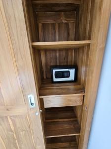 a small cabinet with a microwave inside of it at Casa Dissa in Canggu