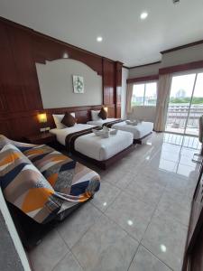 a hotel room with two beds and a balcony at New Forest Patong in Patong Beach