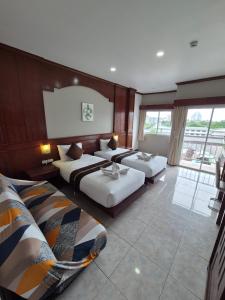 a hotel room with two beds and a large window at New Forest Patong in Patong Beach