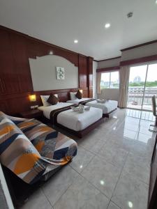 a hotel room with two beds and a balcony at New Forest Patong in Patong Beach