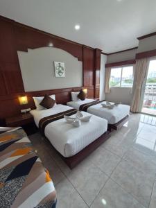 a hotel room with three beds in a room at New Forest Patong in Patong Beach