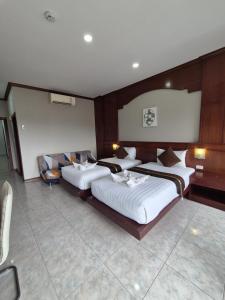 a hotel room with two beds and a couch at New Forest Patong in Patong Beach
