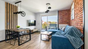 a living room with a blue couch and a brick wall at SOLE MARE Apartamenty Piamola z basenem in Kąty Rybackie