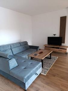 a living room with a blue couch and a coffee table at bb resorts in Kosor +26 photos