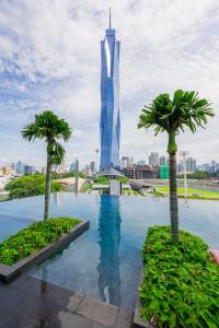 a view of the burj khalifa from a pool with palm trees at 8Pax Green View next to KL118 ChinaTown n Train Station in Kuala Lumpur