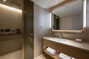 a bathroom with a sink and a mirror at 西安明城墙永兴坊桔子水晶酒店 in Xi'an