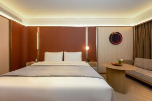 a bedroom with a large bed and a couch at 西安明城墙永兴坊桔子水晶酒店 in Xi'an