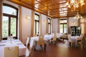 a dining room with white tables and chairs and windows at Villa Luzzago in Ponte di Legno +28 photos