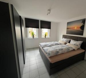 a bedroom with a large bed and two windows at Ferienwohnung Bernhardt in Lindau