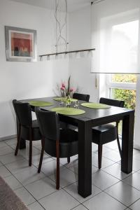 a dining room with a black table and chairs at Ferienwohnung Bernhardt in Lindau +9 photos