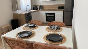 a kitchen with a table with plates and wine glasses at Le Carré Hénaux in Lille