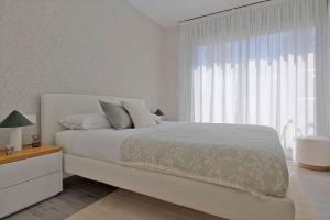 ein Schlafzimmer mit einem großen Bett und einem großen Fenster in der Unterkunft Elegant Apartment in Vitta Natura Mijas in Mijas Costa + 18 Fotos