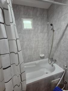 a bathroom with a tub and a shower curtain at New Forest Patong in Patong Beach