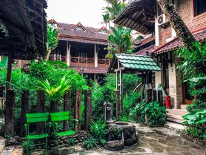a house with green chairs and a fence at Arys Garden Hotel Yogyakarta in Yogyakarta